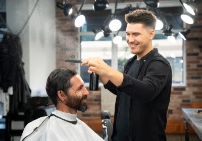 Barber giving a haircut to a satisfied customer in a stylish grooming salon